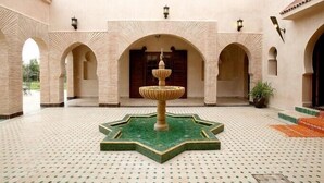 A courtyard with a central fountain, arches, and tiled flooring. - Villa Dar Mya Palmiers (Marrakech)