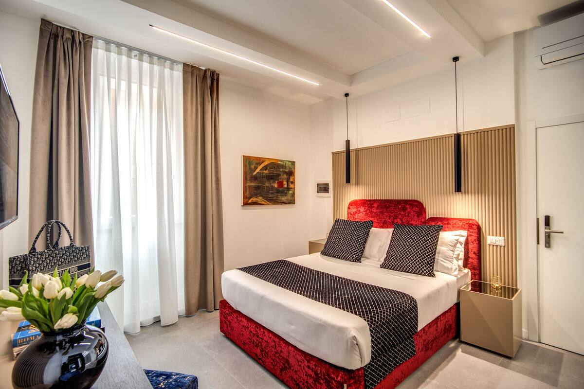 Ein modernes Hotelzimmer mit einem großen Bett, einem Nachttisch, einer Lampe und einem Bild an der Wand.