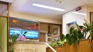 A hotel reception area with a staircase leading to the upper floor. - Hotel Gloria (Gabicce Mare)