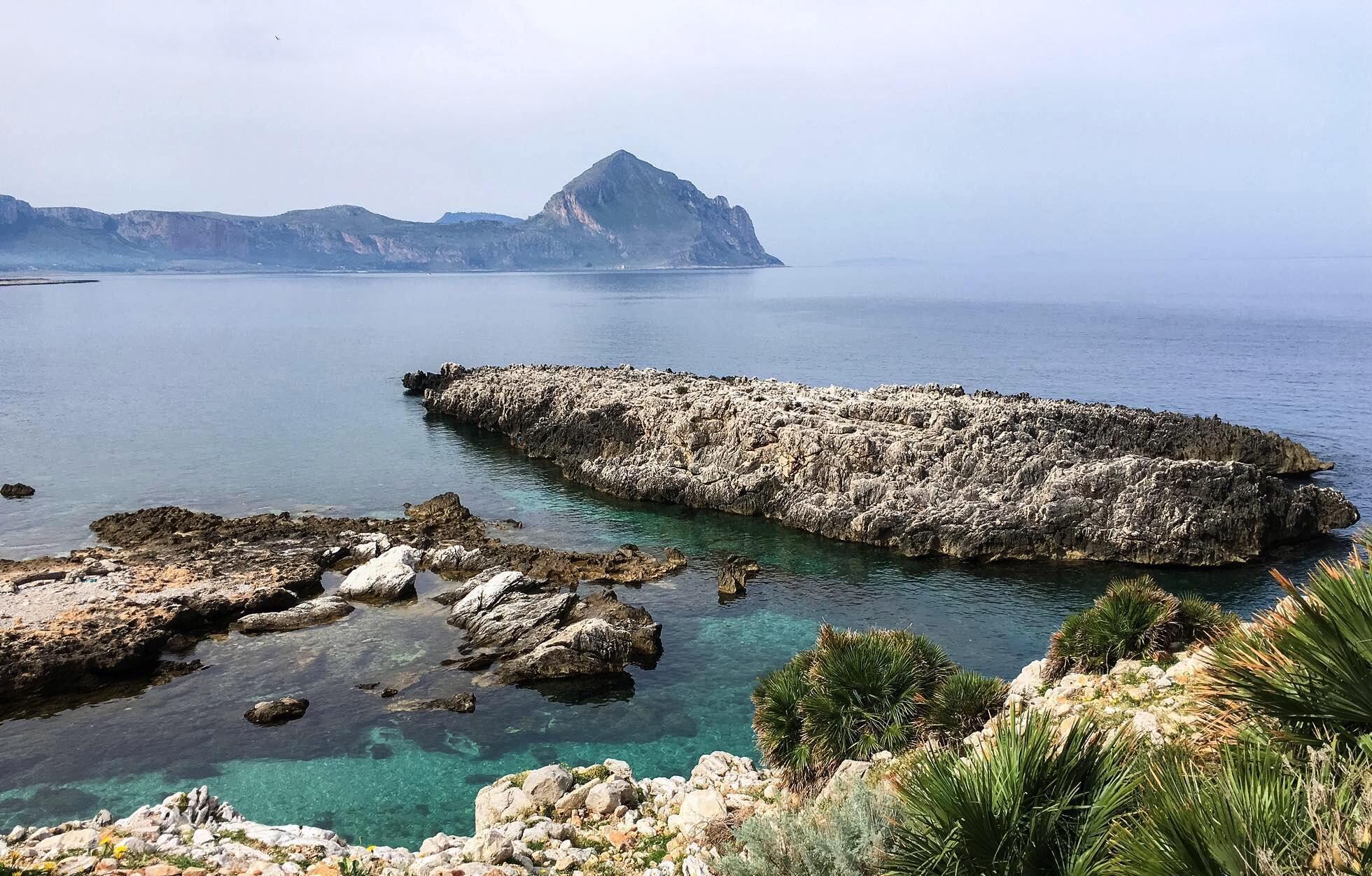 Un paisaje costero con formaciones rocosas y aguas azul cristalino.