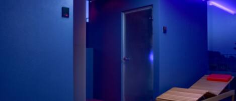 A room with a wooden bench, a door, and blue lighting.