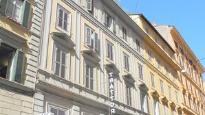 A hotel with a classic facade, multiple balconies, and a sign indicating it is a hotel. - Hotel Corona (Rome)