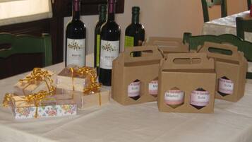Una mesa con botellas de vino, cajas de regalo y bolsas de papel etiquetadas.