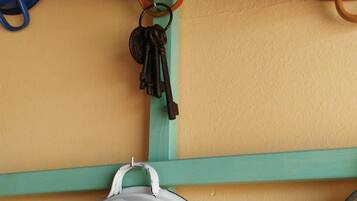 A kitchen with hanging pots and pans on a teal shelf.