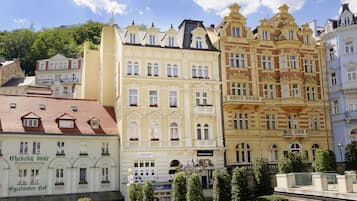 A row of historic European buildings with varied architectural styles, including ornate facades and multiple windows.
