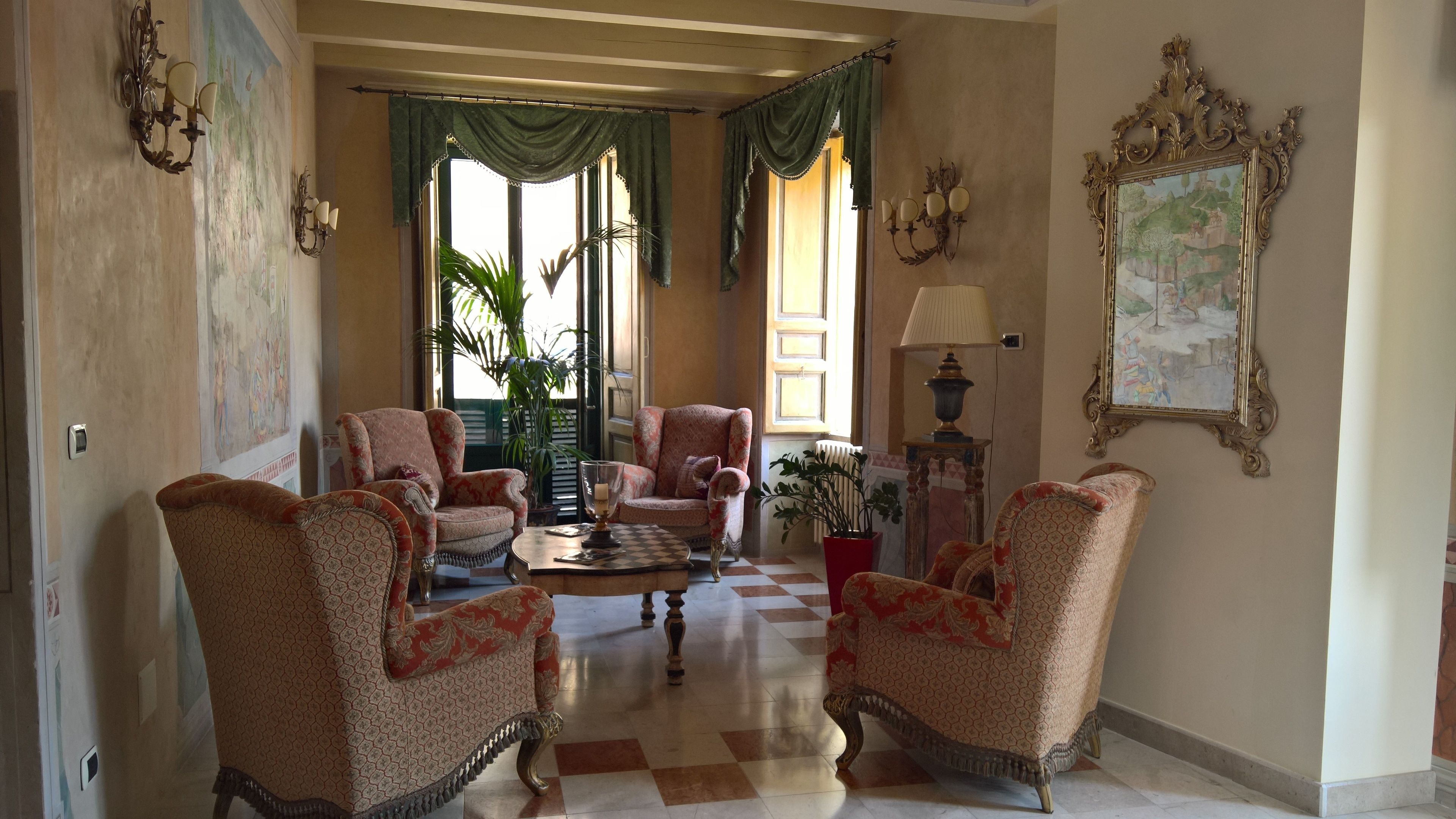 A spacious living room with a checkered floor, two armchairs, a sofa, a coffee table, and a lamp.