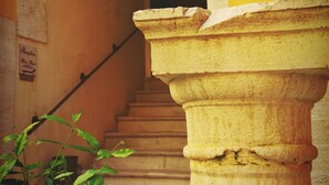 A staircase with stone columns and an archway leading to a dark interior. - Antichi Feudi Dimora d'Epoca (Teggiano)