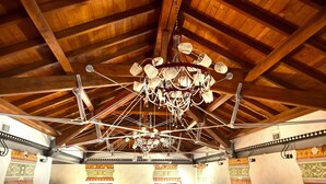 A high-ceilinged room with exposed wooden beams and a complex chandelier. - Antichi Feudi Dimora d'Epoca (Teggiano)
