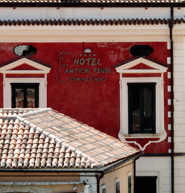 A red building with a sign that reads "HOTEL ANTICI FEUDI."