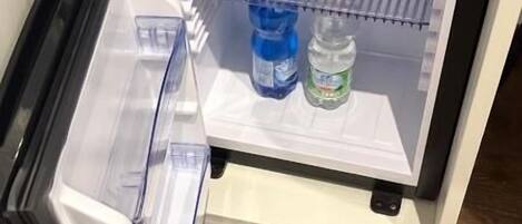A refrigerator with a control panel, a freezer compartment, and shelves with water bottles.
