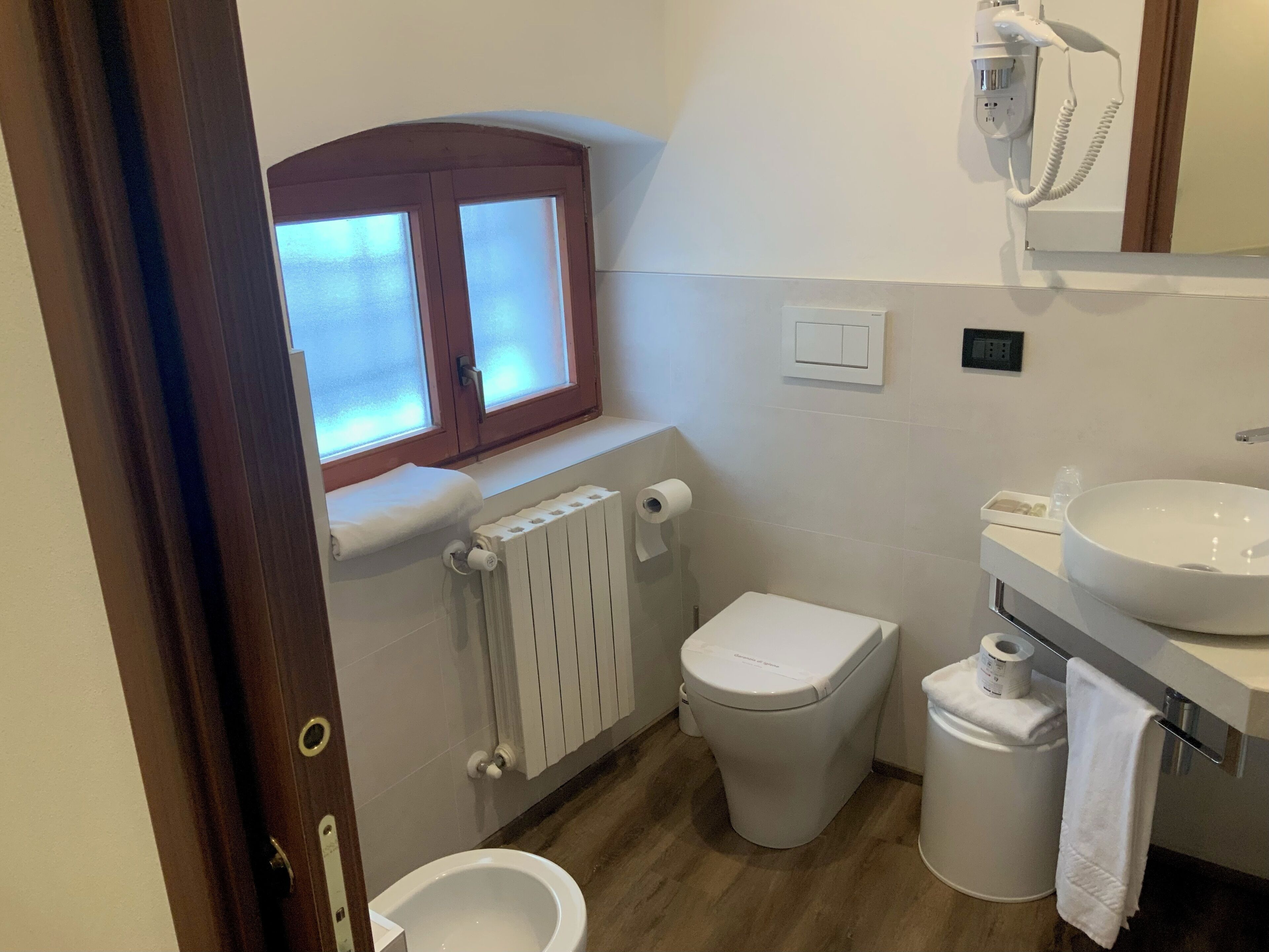 A compact bathroom with a toilet, bidet, and sink.