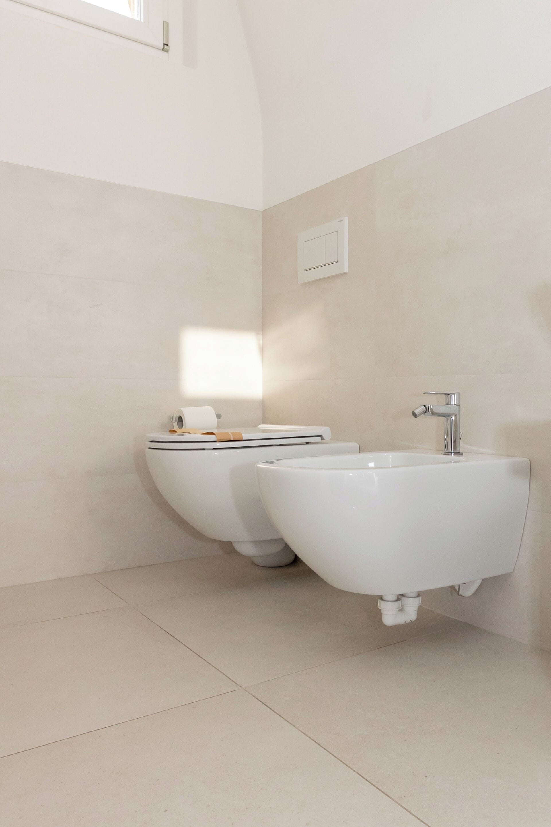 A modern bathroom with a toilet, bidet, and sink.