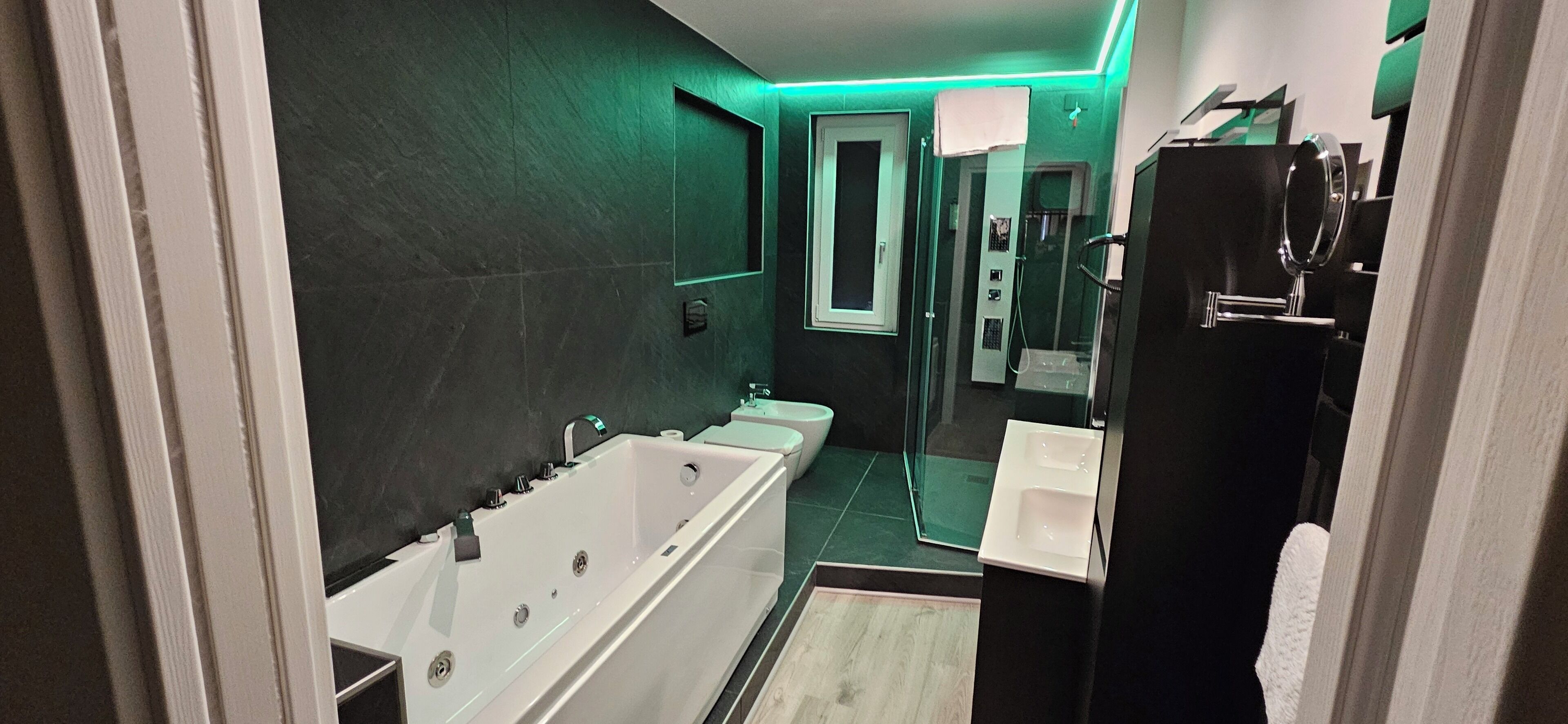 Un baño moderno con una bañera grande, una zona de ducha separada y un tocador con espejo.