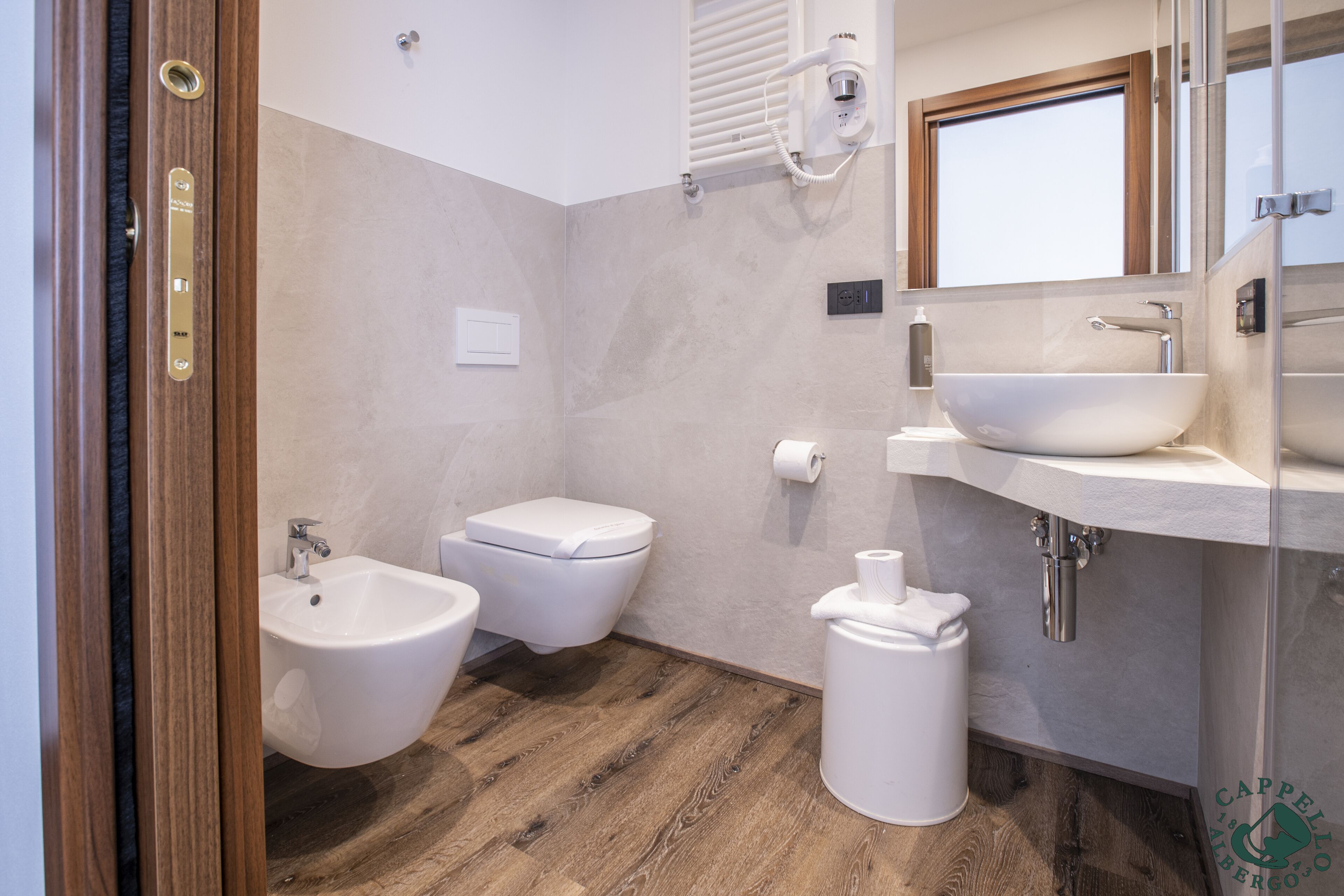 A modern bathroom with a bidet, toilet, and sink.