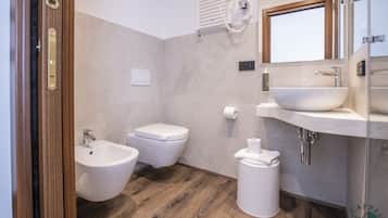 A modern bathroom with a bidet, toilet, and sink.