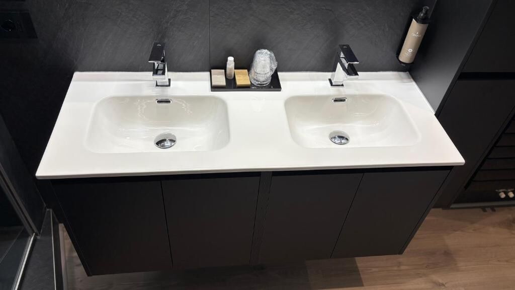 A bathroom with two sinks, dark cabinetry, and a mirror.