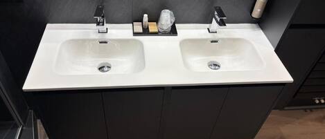A bathroom with two sinks, dark cabinetry, and a mirror.