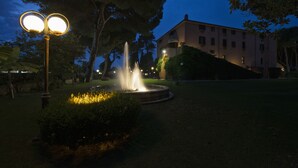 A fountain in a garden with a building in the background. - La Pineta dei Liberti (Ardea)