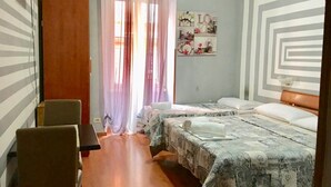 A hotel room with two beds, a wooden floor, a chair, and a window with sheer curtains.