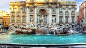 A grand building with a large fountain in front.