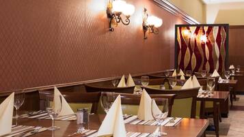 Un restaurant où les tables sont dressées avec des serviettes blanches, des couverts en argent et des verres à vin.