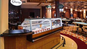 A bar area with a counter, a display case, and a sign that reads "Gloria".