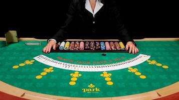 A blackjack table with a dealer and a row of chips.