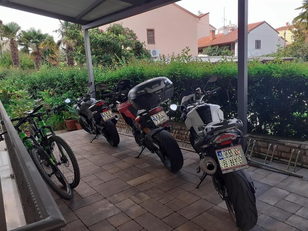 Un espacio al aire libre cubierto con dos motocicletas estacionadas y una bicicleta.