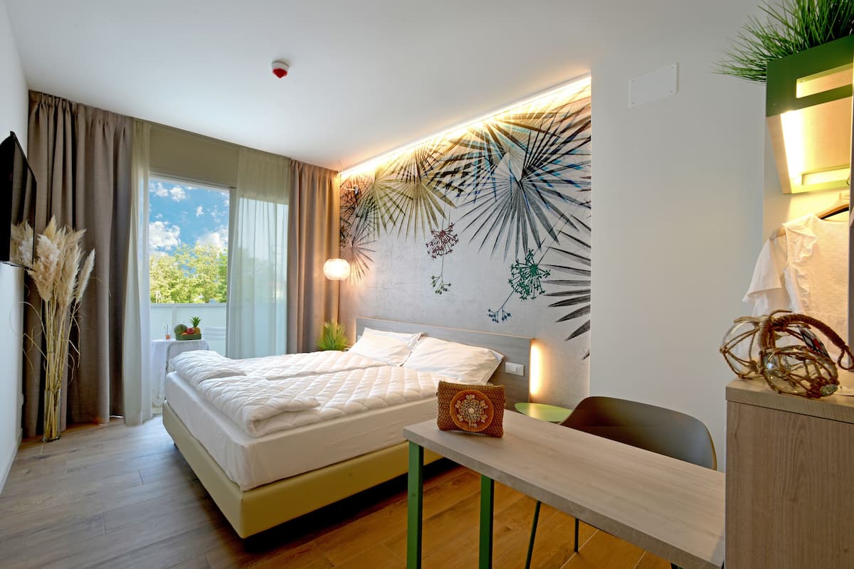 Habitación de hotel moderna con una cama, un escritorio y vistas al exterior.