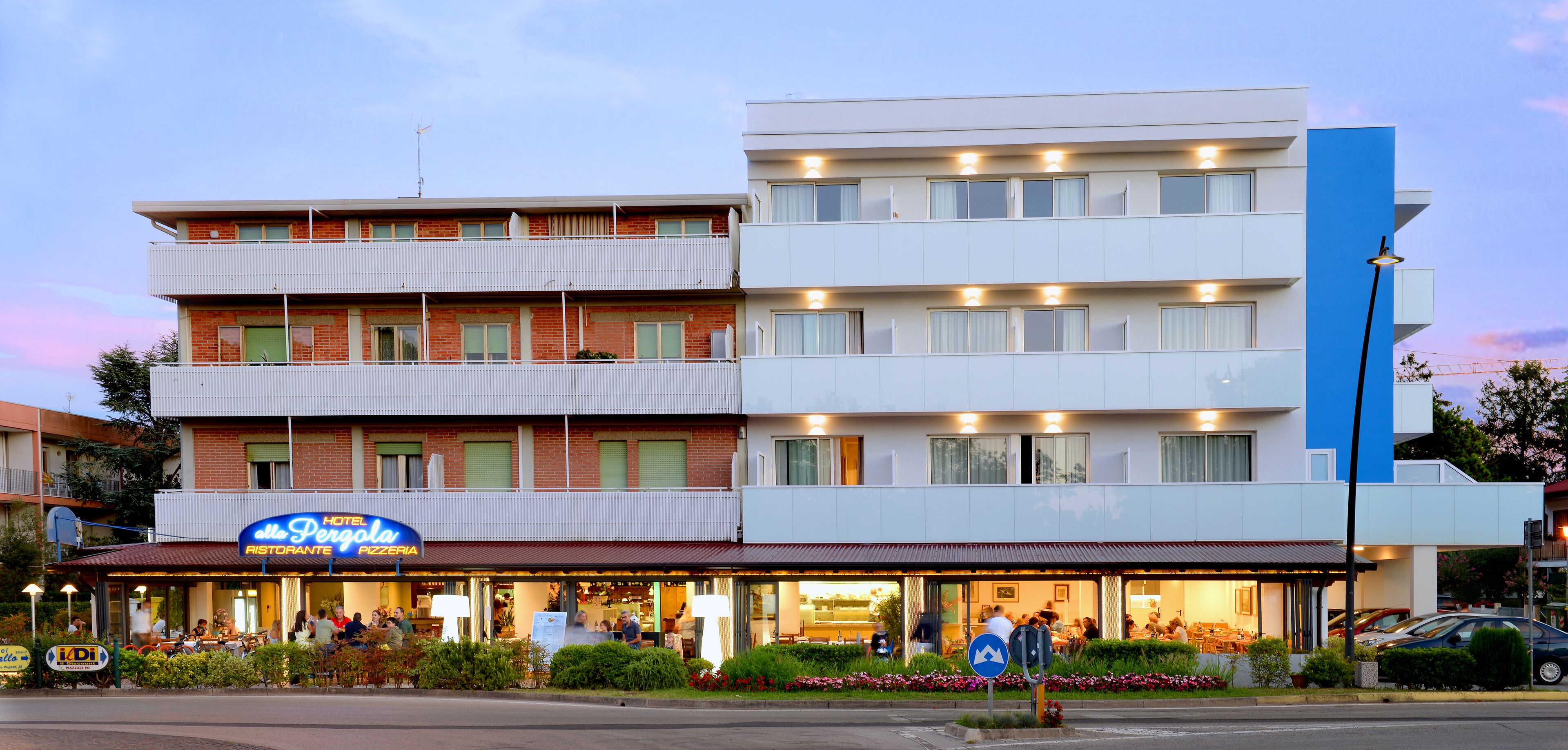 A hotel with a restaurant on the ground floor, multiple balconies, and a modern design.