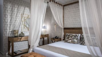 A bedroom with a bed, bedside tables, a nightstand, a lamp, and a decorative mirror.