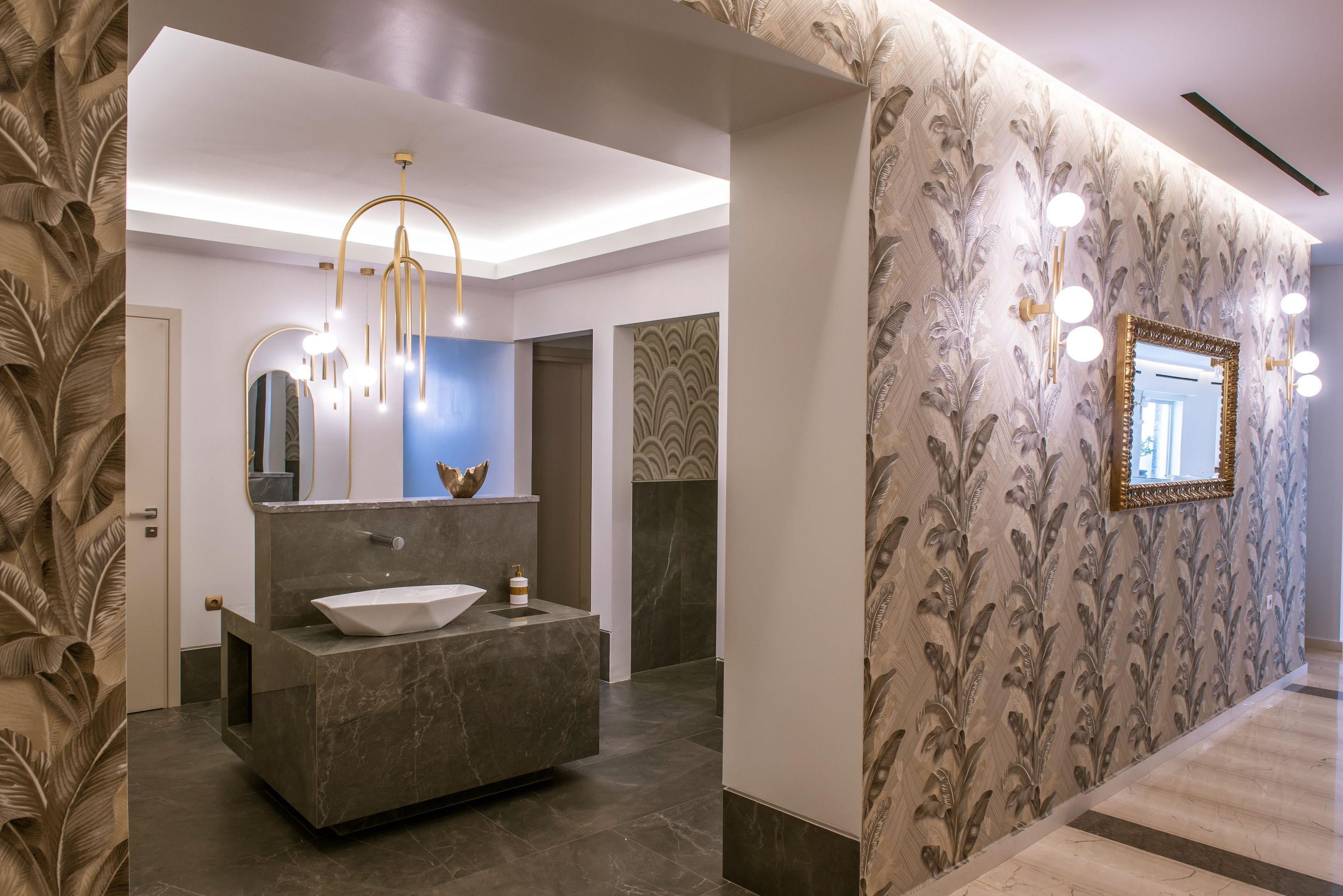 A modern bathroom with a marble vanity, a large mirror, and a chandelier.