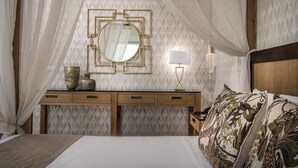 Een slaapkamer met een hemelbed, nachtkastje met een lamp en een spiegel aan de muur.