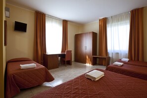 A hotel room with two beds, a desk, a chair, and a wardrobe. - Hotel San Martino (Syracuse)