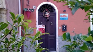 A building with a dark door, a number '4' sign, a flower basket, and a sign for 'I Mastruzzi Bed & Breakfast'. - I Mastrazzi B & B (Riposto)