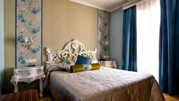 Un dormitorio con una cama grande, dos mesitas de noche y un ventanal con cortinas azules.
