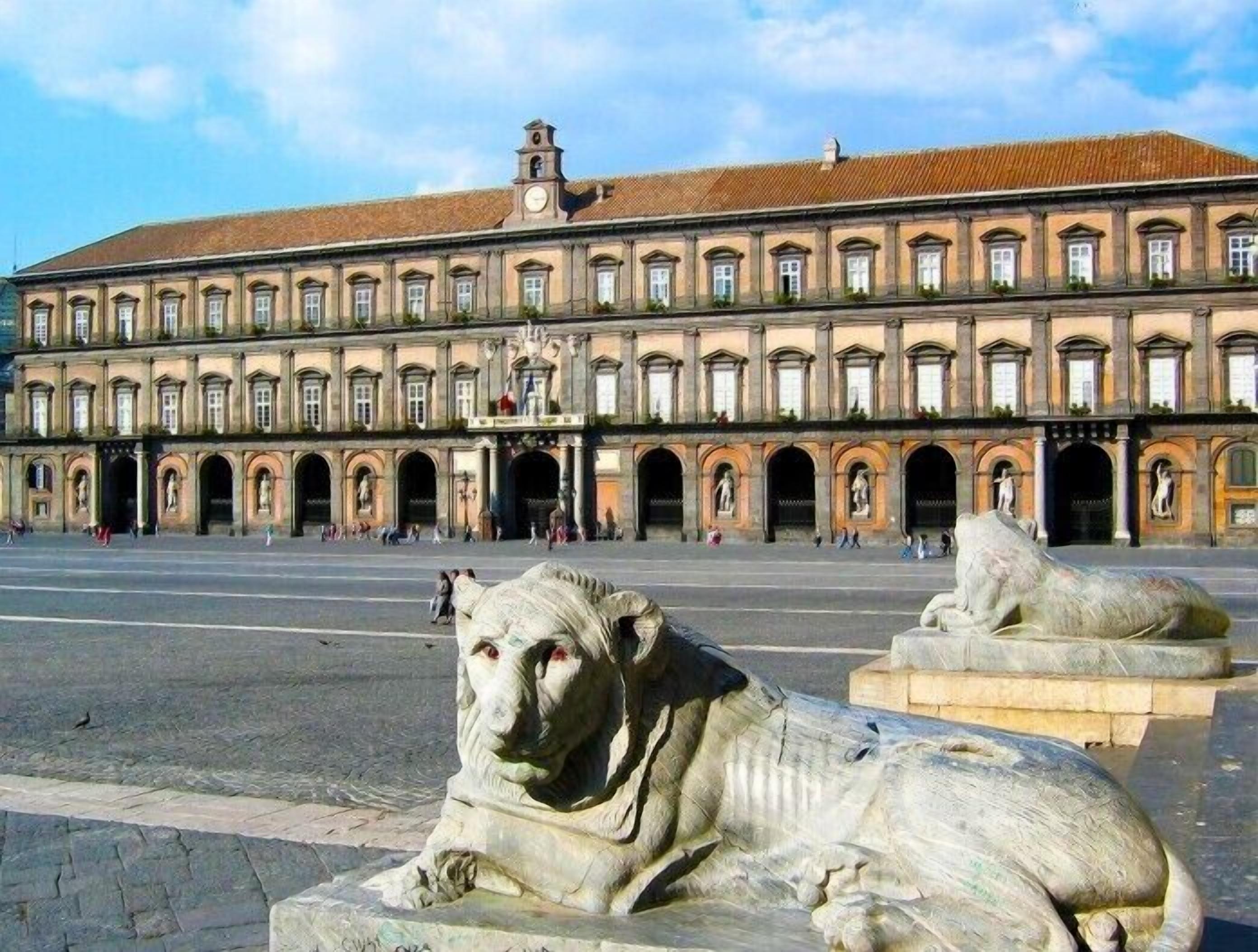 A large historic building with a central courtyard, featuring classical architecture and statues.