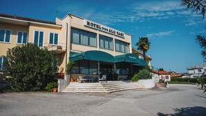 Un hotel con un letrero que dice "HOTEL ALI CASI" y un área de estar al aire libre cubierta.