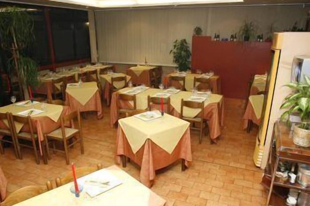 A dining area with multiple tables and chairs, arranged in rows.