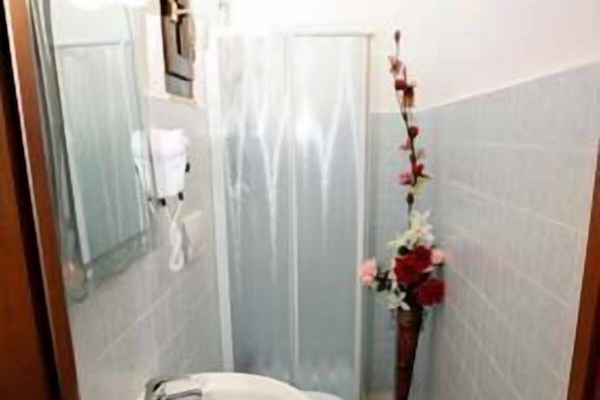 A small bathroom with a white sink, a mirror, and a shower curtain.