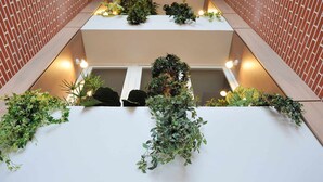 Een meerlaags atrium met groen en verlichting.