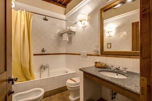 Et badeværelse med badekar, toilet, bidet og håndvask.