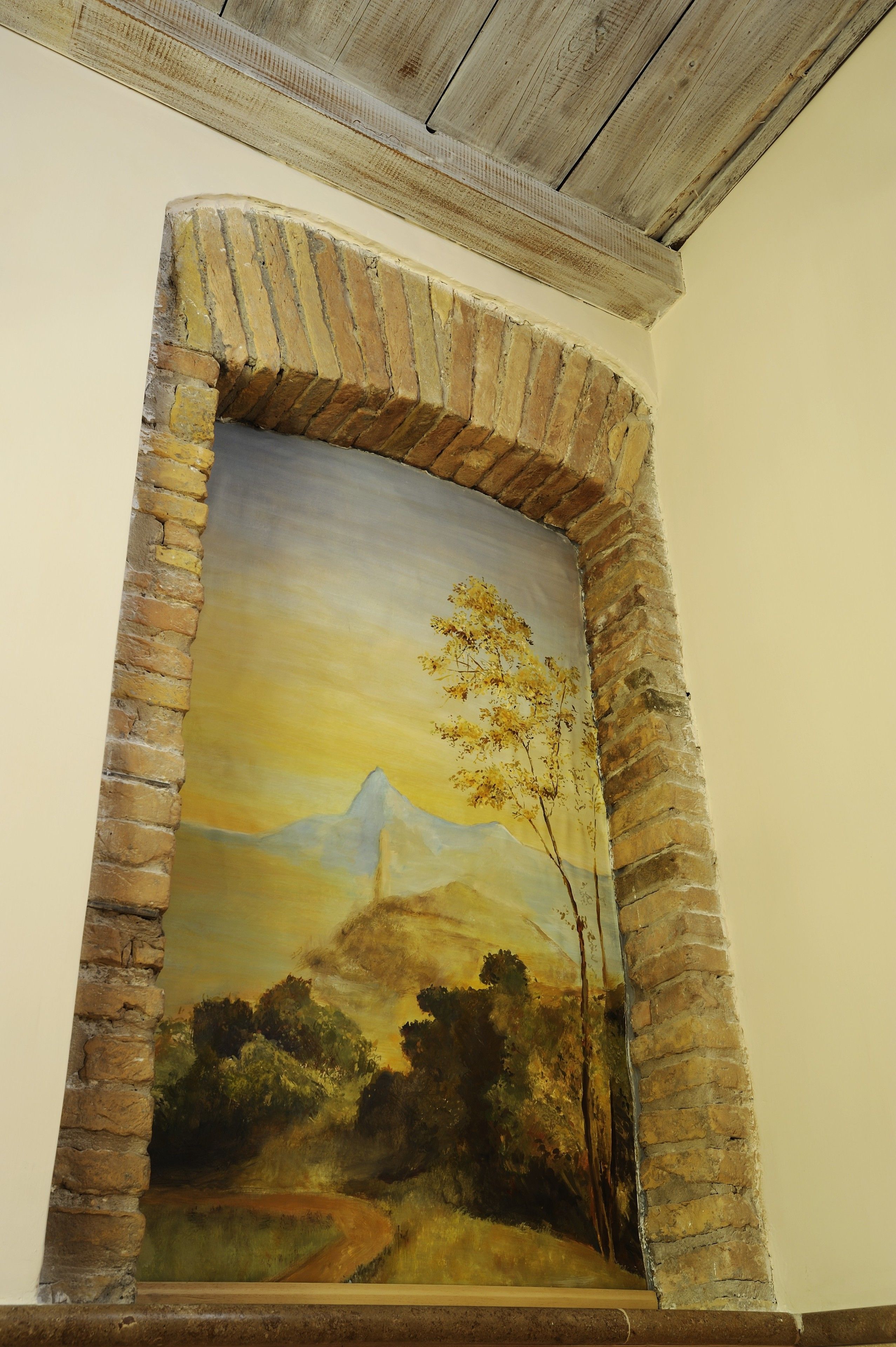 Un mural que muestra una montaña, árboles y un camino.