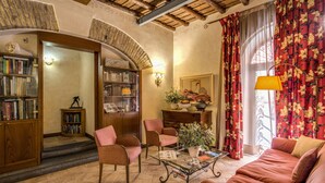 A cozy living room with a fireplace, bookshelves, and comfortable seating. - Residenza San Calisto (Rome)