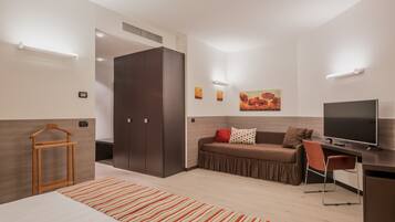 Una habitación de hotel moderna con cama, sofá, escritorio y televisor.