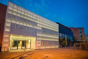 Un edificio moderno con fachada de vidrio y revestimiento metálico con diseño.
