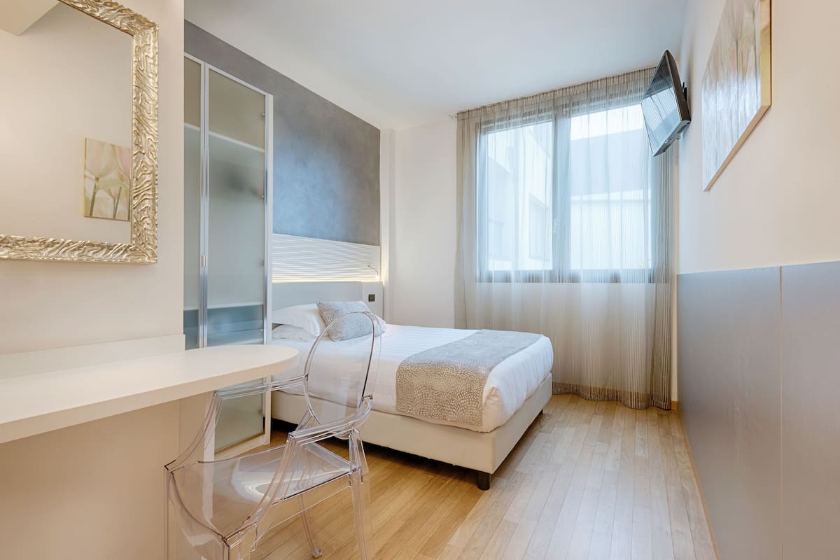 A modern bedroom with a bed, a desk, and a chair.