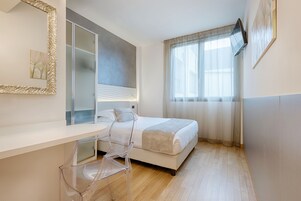Un dormitorio moderno con una cama, un escritorio y una silla.