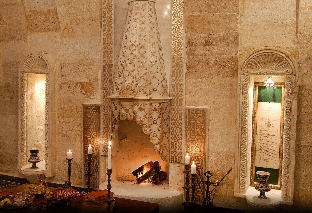 A room with a fireplace, candles, and a decorative mirror.