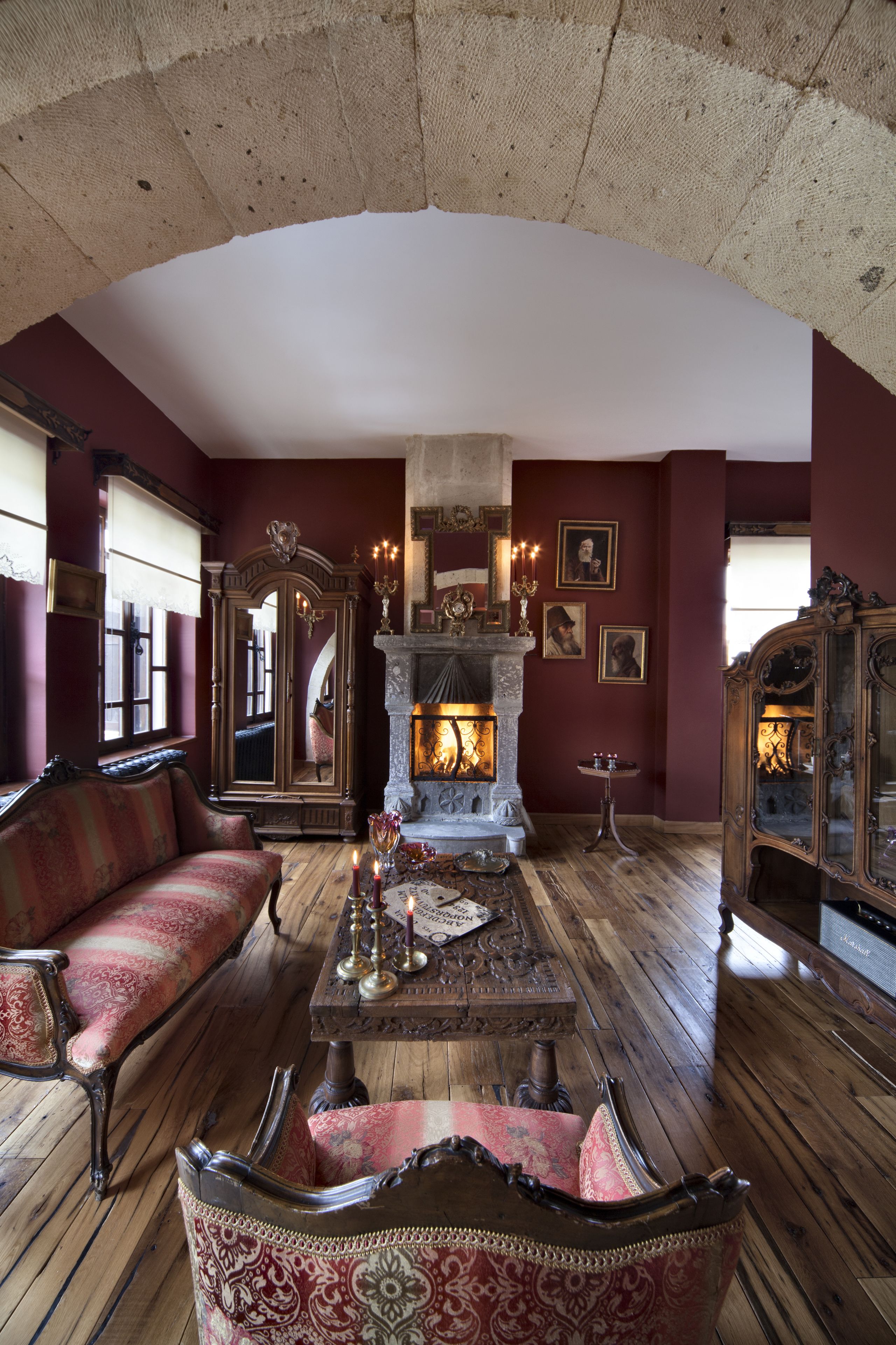 Una habitación de estilo antiguo con chimenea, muebles ornamentales y un espejo.